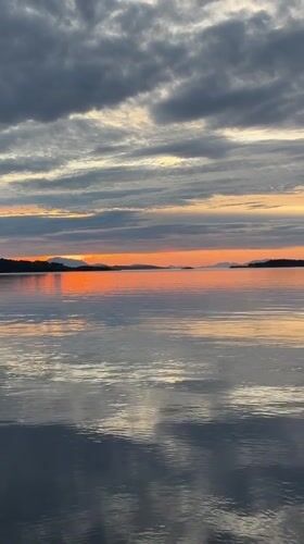 Sunset over calm coastal waters near Harstad, Norway