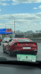 Red Ferrari navigates Moscow traffic during morning commute