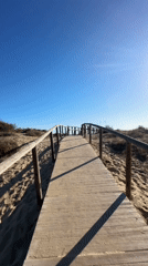 Sunny walk along a dune boardwalk toward the Atlantic in Punta Umbría