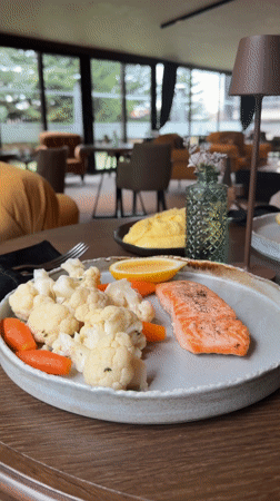 Restaurant meal featuring salmon and vegetables served in Bansko