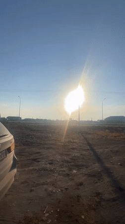 White BMW X5 parked on dusty lot in rural Kazakhstan
