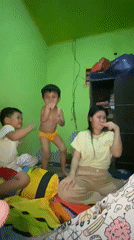 Everyday family time inside a green-walled home in Ta', Indonesia
