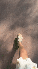 Person in floral dress walks through Scolkovo wearing sandals
