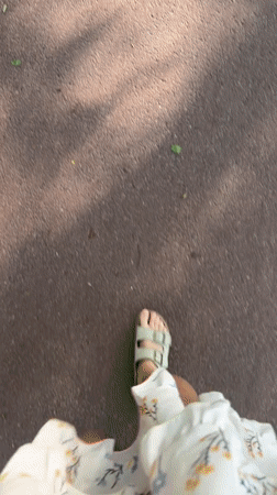 Person in floral dress walks through Scolkovo wearing sandals
