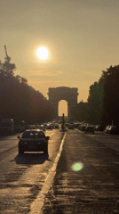 Evening traffic flows past Arc de Triomphe in Paris