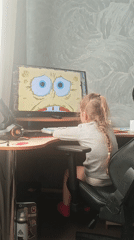Child watches SpongeBob while cat rests during winter morning
