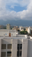 Panoramic daytime view captures Caracas cityscape against mountain backdrop
