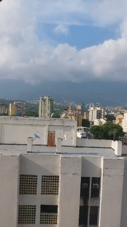 Panoramic daytime view captures Caracas cityscape against mountain backdrop