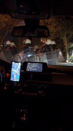Driver navigates through riot police presence in Belgrade suburb