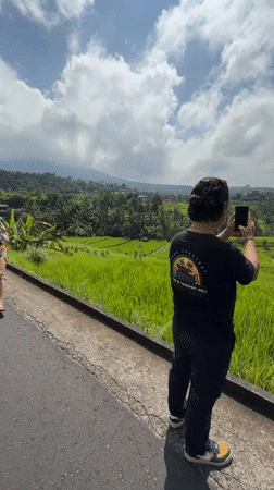 Tourist visits Jatiluwih rice terraces in Bali during sunny morning