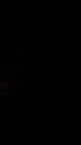 This media file captures a nighttime scene from inside a moving vehicle, likely a car, in Vasavasamudram, India. The footage is dark, indicating it was filmed after sunset. The primary subject is the exterior environment visible through the windows and in the side mirror.

The scene appears to be a rural or semi-rural area, with glimpses of vegetation and possibly some structures or lights in the distance. The road surface is visible intermittently, suggesting the vehicle is driving on it. There are reflections in the side mirror, and the overall atmosphere is one of driving through the dark. No people are directly visible, and the objects are primarily natural elements like trees and the car's own interior components.

The activity taking place is simply driving at night. The time of day is clearly night, and the weather is not discernible from the footage. The location context of Vasavasamudram, India, is provided externally. There are no discernible emotions conveyed, given the lack of human subjects and the low-light conditions. No visible text is present within the frames. The footage is characterized by its darkness and the limited visibility of the surroundings.