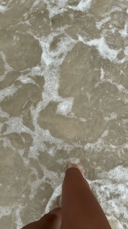 Morning beachgoers wade along Vietnam's overcast coastal waters