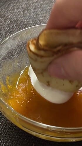 Cream-filled crepe dipped in orange jam in Gelendzhik