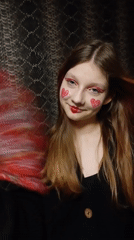 Person photographed wearing red theatrical eye makeup