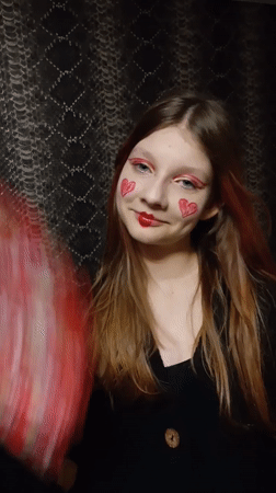 Person photographed wearing red theatrical eye makeup
