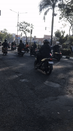 Morning motorcycle traffic flows through Candi and Larangan, Indonesia