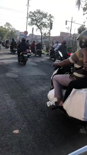 Morning motorcycle traffic flows through Candi and Larangan, Indonesia