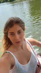 Woman films selfies during afternoon boat ride on Paris waterway