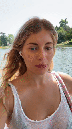 Woman films selfies during afternoon boat ride on Paris waterway