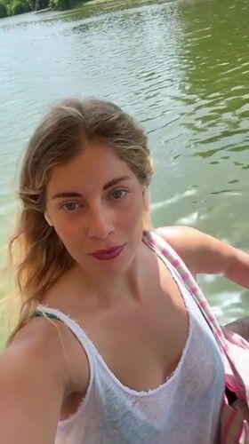 Woman films selfies during afternoon boat ride on Paris waterway