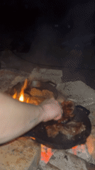 Men cook outdoor meal over campfire in Varna, Bulgaria