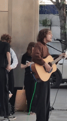 Street musicians busk across Moscow sidewalks during evening hours