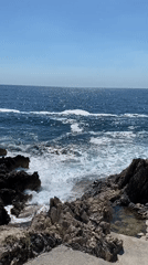 Tattooed woman enjoys afternoon at rocky Montenegro coastline