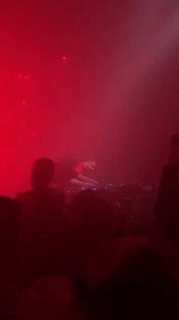 DJ mixing at red-lit nightclub venue