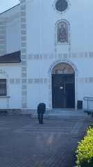 Man approaches white church in Pomorie, Bulgaria early morning