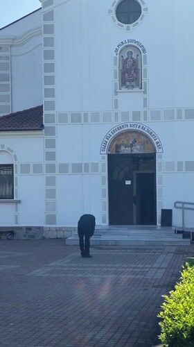 Man approaches white church in Pomorie, Bulgaria early morning