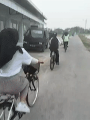 Four cyclists ride concrete path in Gadingan, Indonesia