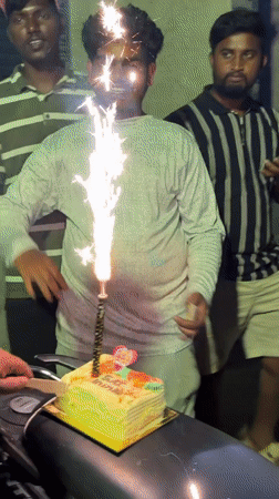 Men celebrate birthday with cake on motorcycle in India