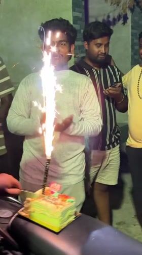 Men celebrate birthday with cake on motorcycle in India