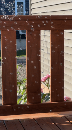 Soap bubbles float across a sunny backyard deck in Dieppe