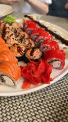 Two diners share sushi meal using chopsticks and fork