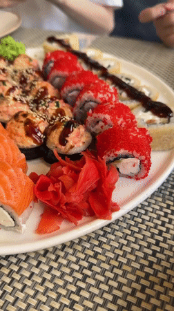 Two diners share sushi meal using chopsticks and fork