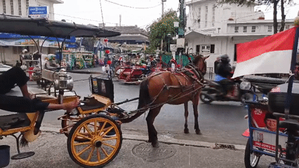 Yogyakarta street life: carriages, vendors, and foot traffic on Malioboro
