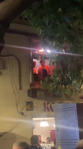 Late-night Barcelona street party with window DJ