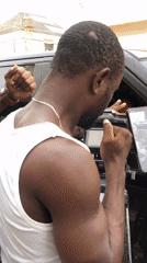 Two men film scene with Lexus SUV in Lagos