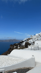 Clear skies frame Santorini's whitewashed buildings in morning view