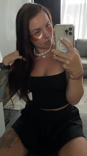 Selfie session with under-eye patches and a shell necklace