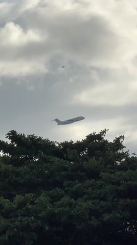 Black smoke rises near Kuta Beach as planes pass overhead