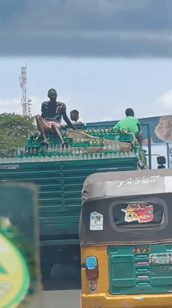 Overloaded beverage truck carries three passengers atop cargo in Nigeria