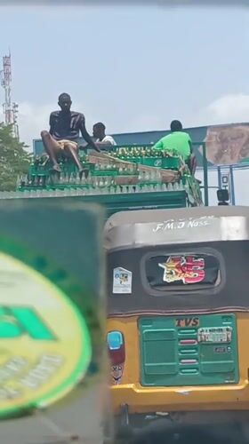 Overloaded beverage truck carries three passengers atop cargo in Nigeria