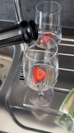Person enjoys strawberry-garnished wine on deck in Kiel