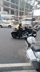 Motorcycles parked on Nha Trang street, man adjusts bike