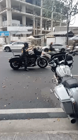 Motorcycles parked on Nha Trang street, man adjusts bike