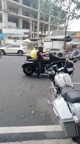 Motorcycles parked on Nha Trang street, man adjusts bike