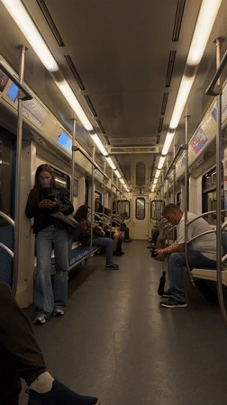 Moscow Metro passengers on phones during midday commute