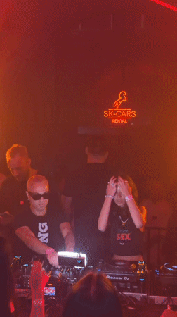 DJ mid-set at a Warsaw nightclub under orange lights